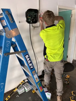 EWJ Electrical electrician wiring an EV charger unit in a Brisbane garage