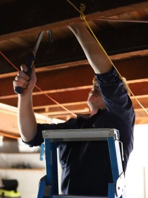 EWJ Electrical electrician on a ladder installing garage lighting in Brisbane
