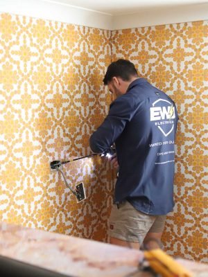 EWJ Electrical electrician drilling a wall to install a new power point in Brisbane